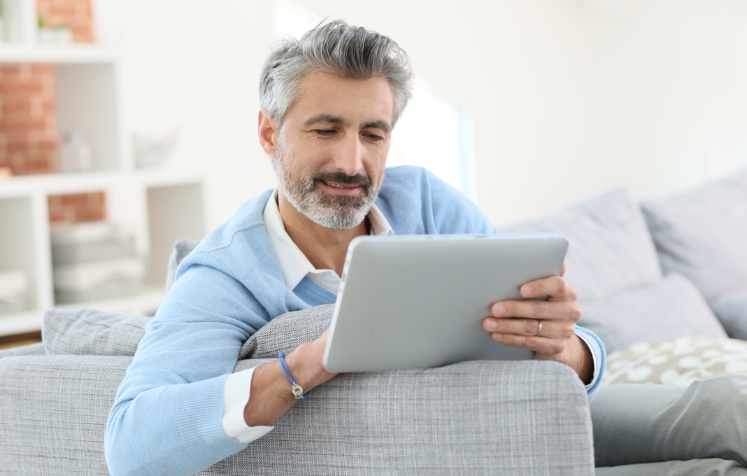 Mature man sending email with digital tablet